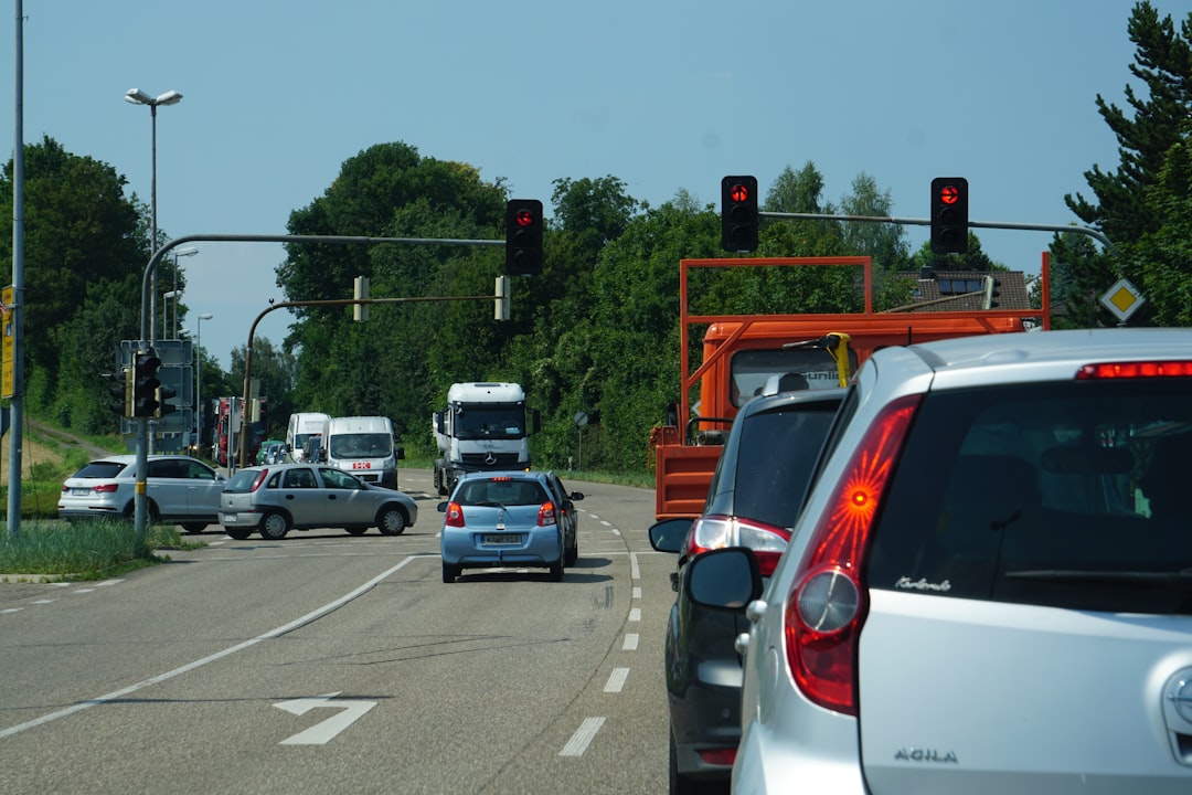 Red brake and tail lights glowing on vehicles stopped in traffic, the kind of red-light wait that can expose a weak AC system in summer heat